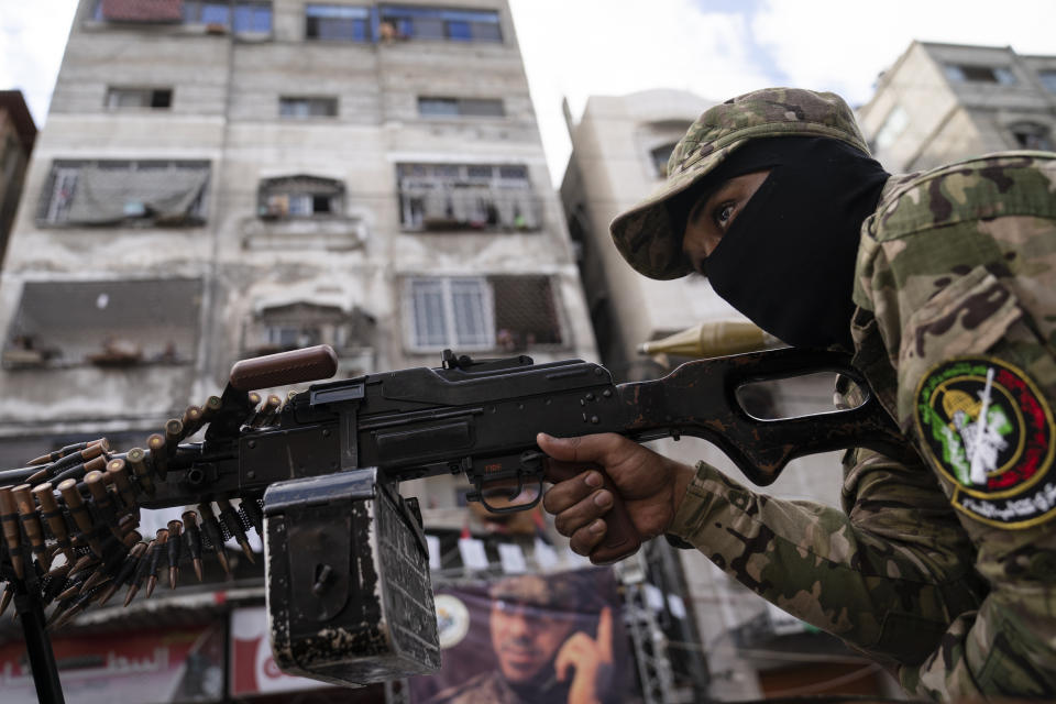 A Hamas militant holds a squad automatic weapon perched atop a truck during a parade through the streets for Bassem Issa, a top Hamas' commander, who was killed by Israeli Defense Force military actions prior to a cease-fire reached after an 11-day war between Gaza's Hamas rulers and Israel, in Gaza City, Saturday, May 22, 2021. (AP Photo/John Minchillo)