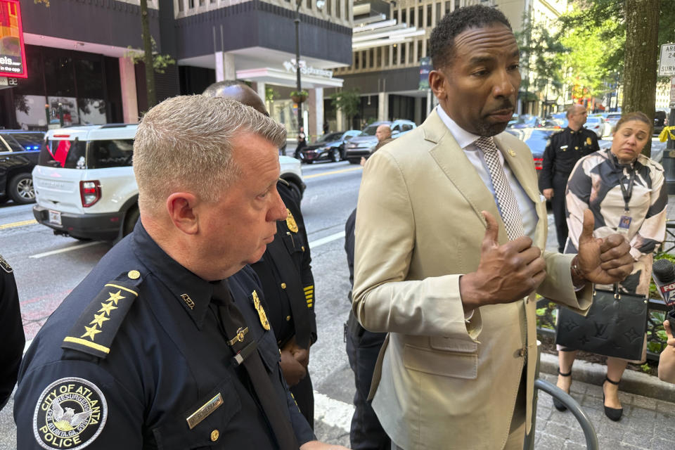 Atlanta Mayor Andre Dickens, right, speaks to reporters as Atlanta Police Chief Darin Schierbaum listens, Tuesday, June 11, 2024, outside a downtown food court where multiple people were shot and injured in Atlanta. (AP Photo/Jeff Amy)