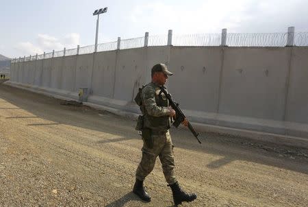 A Turkish soldier patrols along a wall on the border line between Turkey and Syria near the southeastern city of Kilis, Turkey, March 2, 2017. REUTERS/Murad Sezer