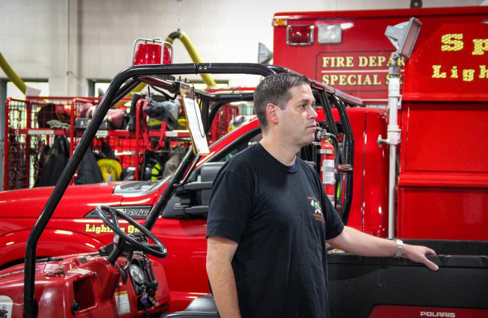 Fall River firefighter Jason Burns stands among several of the specialized vehicles used by the fire department at the North End fire station on Commerce Drive.