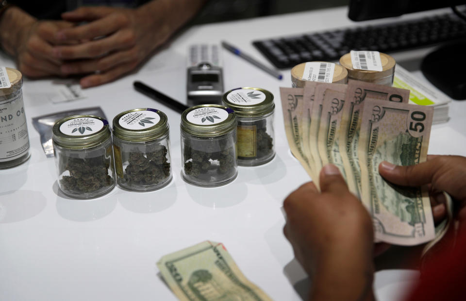 FILE – In this July 1, 2017 file photo, a person buys marijuana at the Essence cannabis dispensary in Las Vegas. . (AP Photo/John Locher, File)