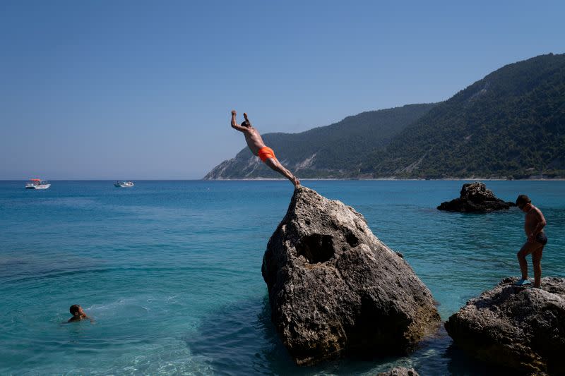 FILE PHOTO: A man dives at Agios Nikitas beach on the island of Lefkada, Greece