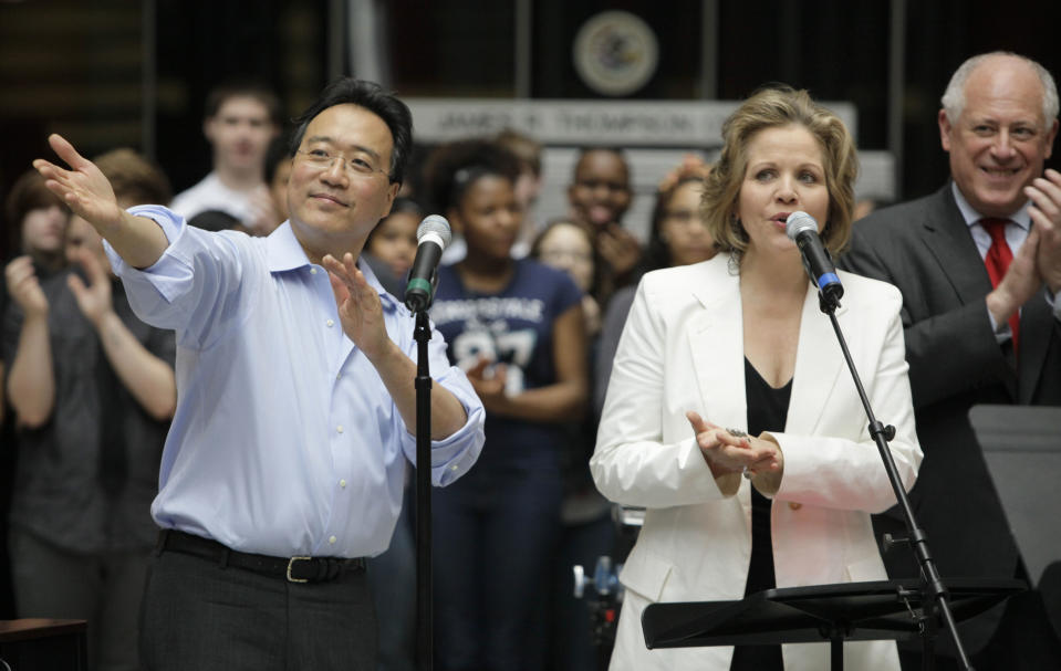 World-famous cellist Yo-Yo Ma, left, and famed soprano Renee Fleming speak as they performed with a choir of dozens of high school students in the rotunda of the State of Illinois building, the James R. Thompson Center, Monday, March 19, 2012, in Chicago. At right is Illinois Gov. Pat Quinn. The Monday afternoon performance was to promote the Chicago Symphony Orchestra's Citizen Musician initiative. The Lyric Opera of Chicago also sponsored the event and Illinois Gov. Pat Quinn attended. (AP Photo/Kiichiro Sato)