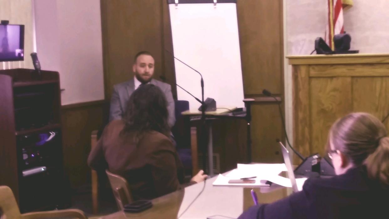 Norton detective Ryan Connell speaks June 6, 2023, in Barberton Municipal Court as assistant prosecutor Michelle Banbury and defendant Dacarrei Tovon Kinard, upper left video screen, listen.