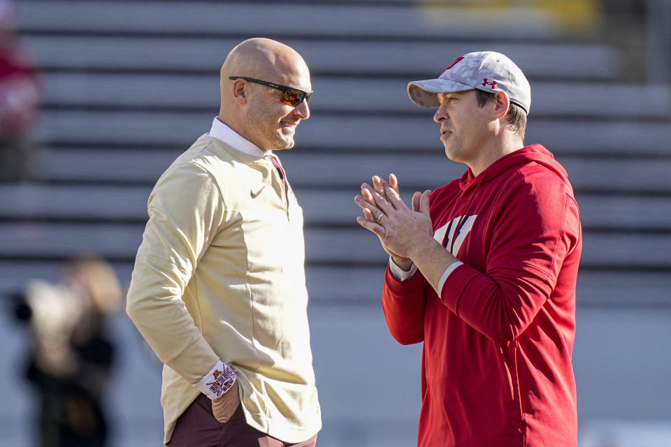 Wisconsin interim head coach Jim Leonhard, right and Minnesota head coach P.J. Fleck talk on the field before an NCAA college football game ta Saturday, Nov. 26, 2022, in Madison, Wis. (AP Photo/Andy Manis)