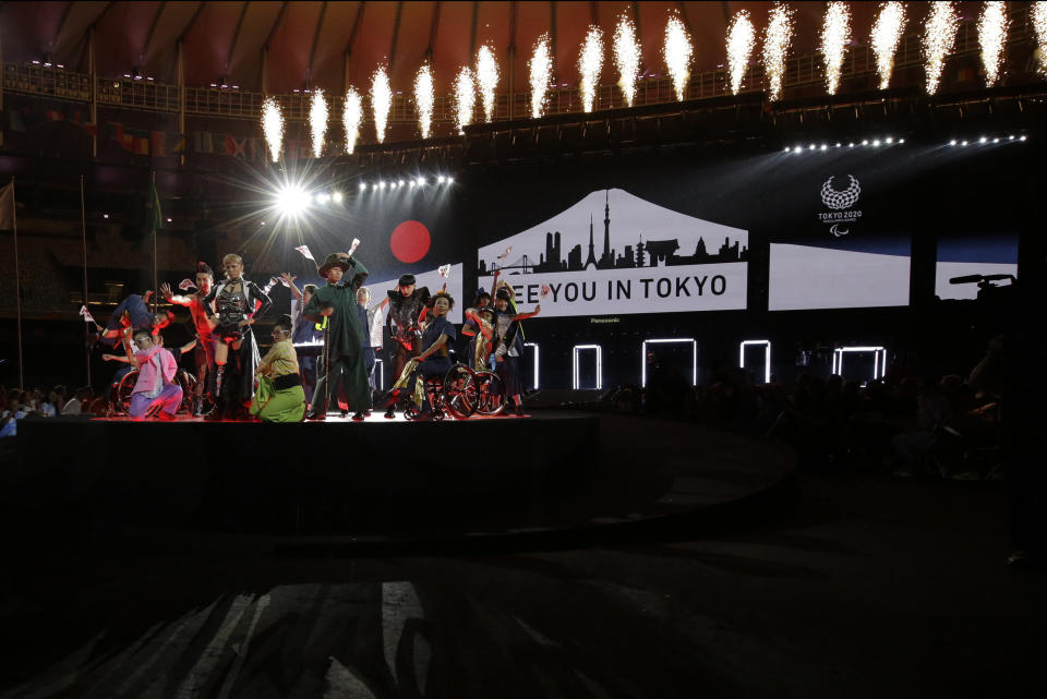 FILE - In this Sunday, Sept. 18, 2016 file photo, performers dance next to a sign that reads: "See you in Tokyo" during the closing ceremony of the Rio 2016 Paralympic Games at the Maracana Stadium in Rio de Janeiro, Brazil. Along with the Olympics, the Paralympics have been pushed back to 2021 because of the coronavirus pandemic. The new dates are Aug. 24-Sept. 5. For many Paralympians, a delay seemed like the only option. Paralympic athletes often have specific medical and training needs which can’t always be met at a time when people are staying home and doctors are helping out overloaded ERs. (AP Photo/Leo Correa, File)