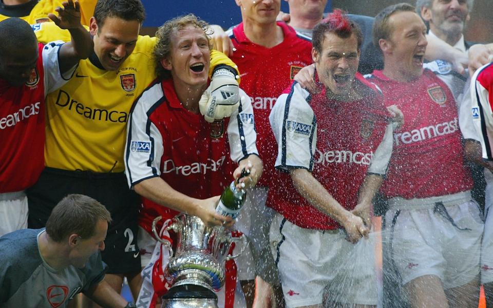 Arsenal goalscorers Fredrik Ljungberg and Ray Parlour celebrate with the trophy