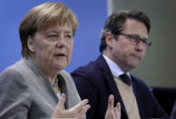 German Chancellor Angela Merkel, left, and German Transportation Minister Andreas Scheuer, right, address the media during a press conference at the chancellery in Berlin, Germany, Monday, Dec. 3, 2018 after a meeting with representatives of German cities that are affected by nitrogen oxide limit violations. (AP Photo/Michael Sohn)