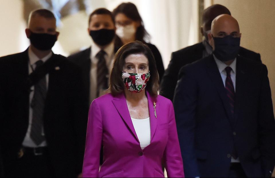 House Speaker Nancy Pelosi walks in the U.S. Capitol on Friday, when the House approved a $3 trillion coronavirus stimulus package.