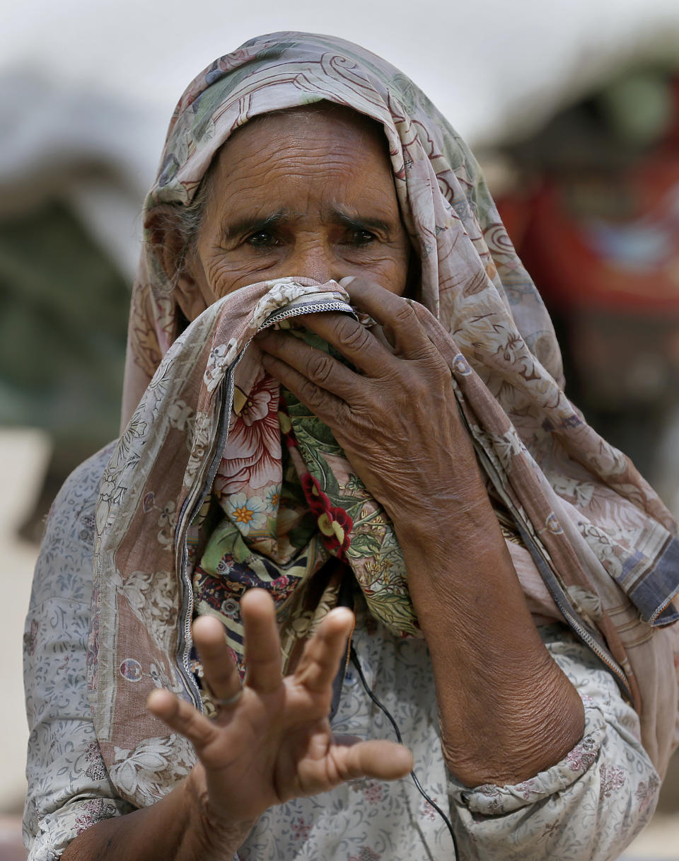 Amina, a long-time neighbor of Ali Hassan, a suspect in an attack on two people with a meat cleaver in Paris last month, talks to The Associated Press, in the village of Kotli Qazi, Pakistan, Saturday, Oct. 3, 2020. Before the attack, Hassan proclaimed in a video that he was seeking vengeance after the French satirical newspaper Charlie Hebdo republished caricatures of Islam’s Prophet Muhammad. Amina remembered Ali as a good boy. She said: “Religiously he did the right thing. You may not agree, but he did right thing.” (AP Photo/Anjum Naveed)