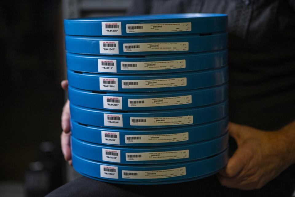 A close-up of hands holding a stack of film reels