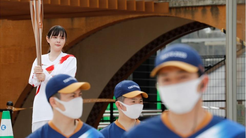 A torch bearer holds the Olympic torch at Futaba station, inside one of the difficult-to-return zones set since Fukushima"s 2011 nuclear disaster, on the first day of the Tokyo 2020 Olympic torch relay, in Futaba, Fukushima Prefecture, Japan March 25, 2021.