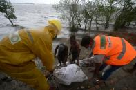 Workers and villagers reinforce an embankment with sacks of soil ahead of the expected landfall of cyclone Amphan, in Dacope on May 20, 2020. - Several million people were taking shelter and praying for the best on Wednesday as the Bay of Bengal's fiercest cyclone in decades roared towards Bangladesh and eastern India, with forecasts of a potentially devastating and deadly storm surge. Authorities have scrambled to evacuate low lying areas in the path of Amphan, which is only the second "super cyclone" to form in the northeastern Indian Ocean since records began. (Photo by Munir Uz zaman / AFP) (Photo by MUNIR UZ ZAMAN/AFP via Getty Images)