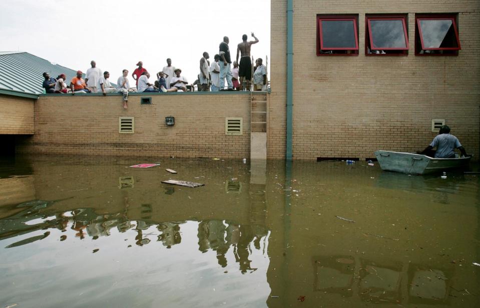 PHOTO: People rest on a school rooftop after being trapped there in high water after Hurricane Katrina, Aug. 30, 2005, in New Orleans. (Mario Tama/Getty Images)