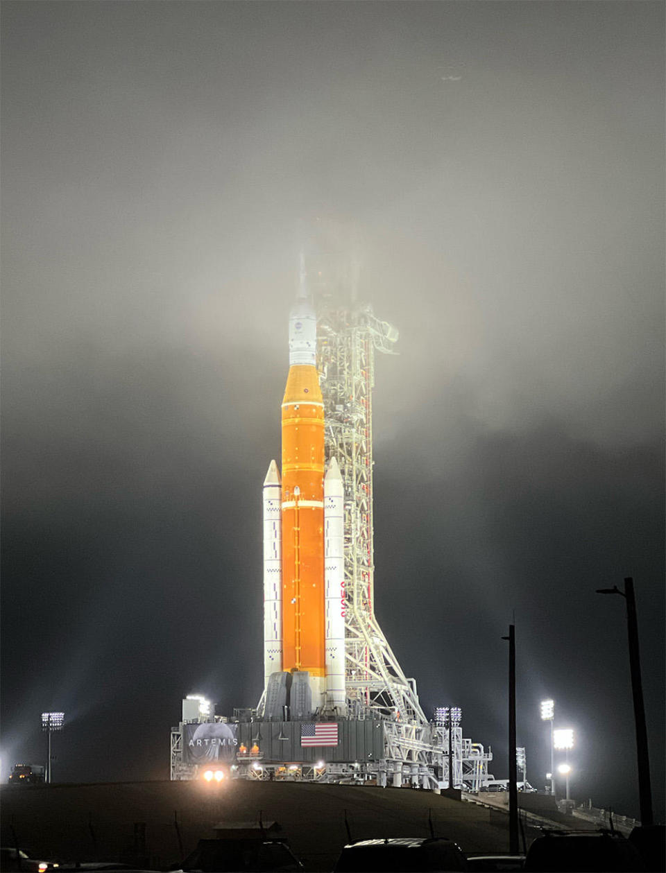 Shrouded in heavy fog, the Space Launch System rocket was mounrted atop pad 39B at the Kennedy Space Center early Friday, setting the stage for a dress-rehearsal countdown early next month. If the test goes well, NASA is expected to launch the rocket on an unpiloted maiden test flight in late May or June. / Credit: Miles Doran/CBS News