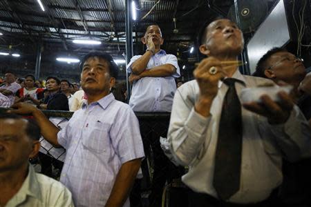 Spectators follow a fight during the closing Thai boxing, or "Muay Thai", fight night of the legendary Lumpinee stadium, one of Bangkok's oldest boxing venues which is being demolished after 57 years, February 7, 2014. REUTERS/Damir Sagolj