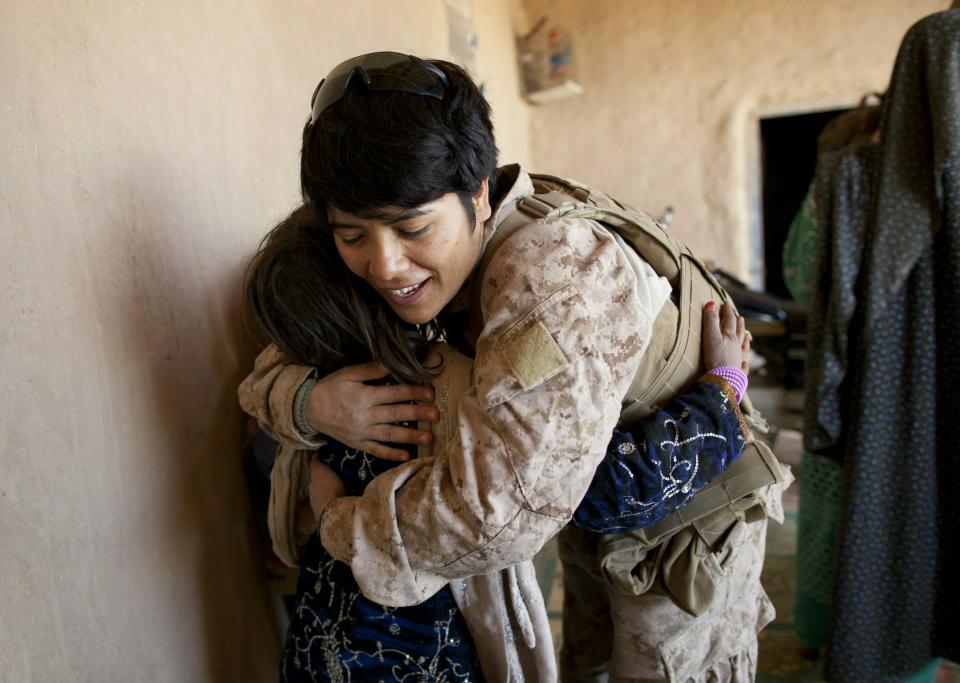 BOLDOC, AFGHANISTAN - NOVEMBER 23: (SPAIN OUT, FRANCE OUT, AFP OUT) Lance Corporal Luz Lopez, 21, a US Marine with the FET (Female Engagement Team) 1st Battalion 8th Marines, Regimental Combat team II hugs an Afghan girl during a village medical outreach on November 23, 2010 in Boldoc, in Helmand province, Afghanistan. There are 48 women presently working along the volatile front lines of the war in Afghanistan deployed as the second Female Engagement team participating in a more active role, gaining access where men can't. The women, many who volunteer for the 6.5 month deployment take a 10 week course at Camp Pendleton in California where they are trained for any possible situation, including learning Afghan customs and basic Pashtun language. (Photo by Paula Bronstein/Getty Images)