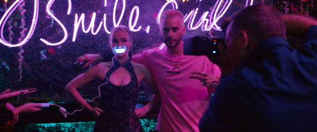 Danni, in her qipao dress, samples some swag at an influencer party with Colin (Dylan O'Brien), wearing a Balenciaga T-shirt.<p>Photo: Courtesy of Searchlight Pictures</p>