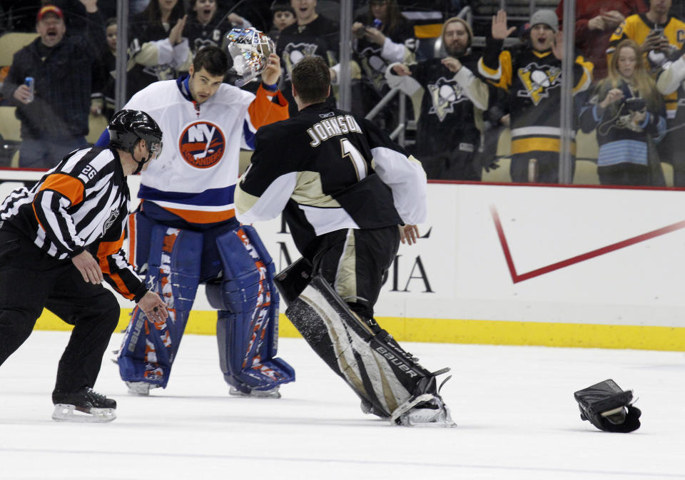 FILE - Pittsburgh Penguins goalie Brent Johnson (1) fights with New York Islanders goalie Rick DiPietro, second from left, in the third period of an NHL hockey game in Pittsburgh, Feb. 2, 2011. The league rule changes have made it so punitive that goalie fighting has essentially disappeared from the highest level of hockey. (AP Photo/Gene J. Puskar, File)