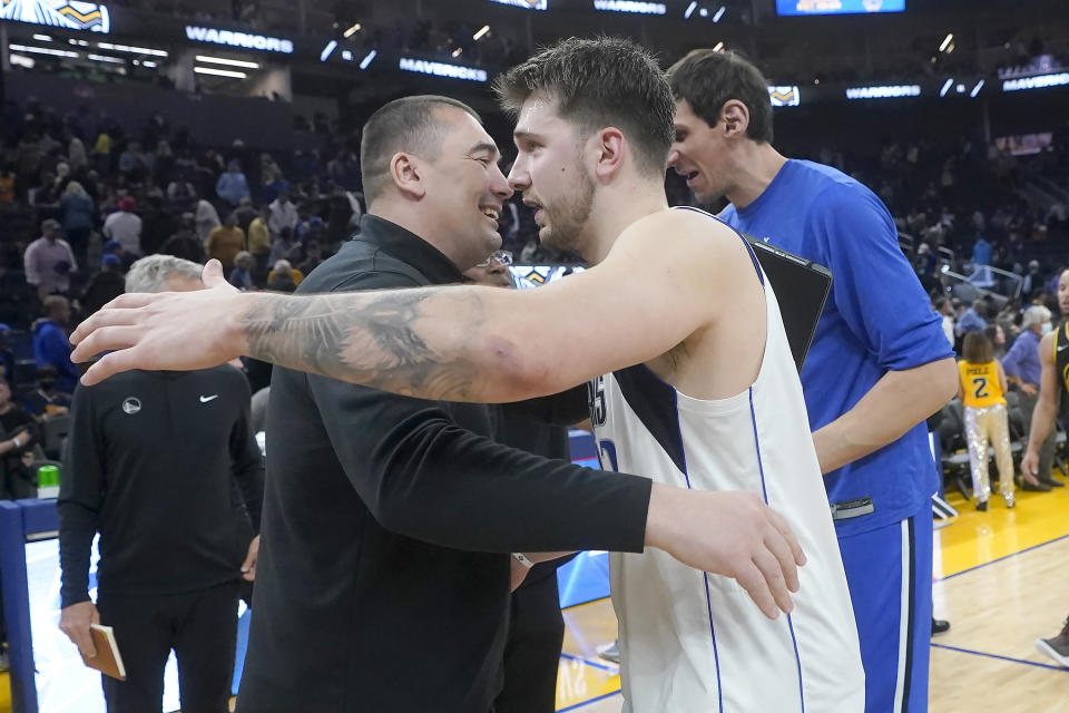 Golden State Warriors assistant coach Dejan Milojevic, foreground left, hugs Dallas Mavericks guard Luka Doncic after an NBA basketball game in San Francisco, Sunday, Feb. 27, 2022. Warriors assistant coach Dejan Milojević, a mentor to two-time NBA MVP Nikola Jokic and a former star player in his native Serbia, died Wednesday, Jan. 17, 2024, after suffering a heart attack, the team announced. Milojević, part of the staff that helped the Warriors win the 2022 NBA championship, was 46. (AP Photo/Jeff Chiu)