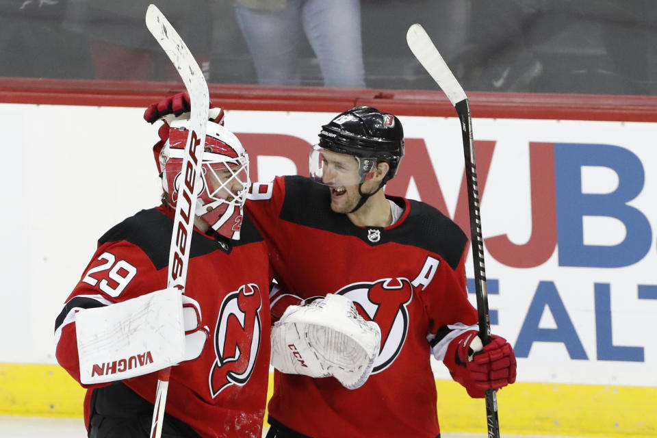 New Jersey Devils center Travis Zajac (19) celebrates with Devils goaltender Mackenzie Blackwood (29) after the Devils defeated the Boston Bruins in a shootout in an NHL hockey game, Tuesday, Dec. 31, 2019, in Newark, N.J. Devils defenseman Damon Severson scofred the game-deciding goal for a 3-2 victory over the Bruins. (AP Photo/Kathy Willens)