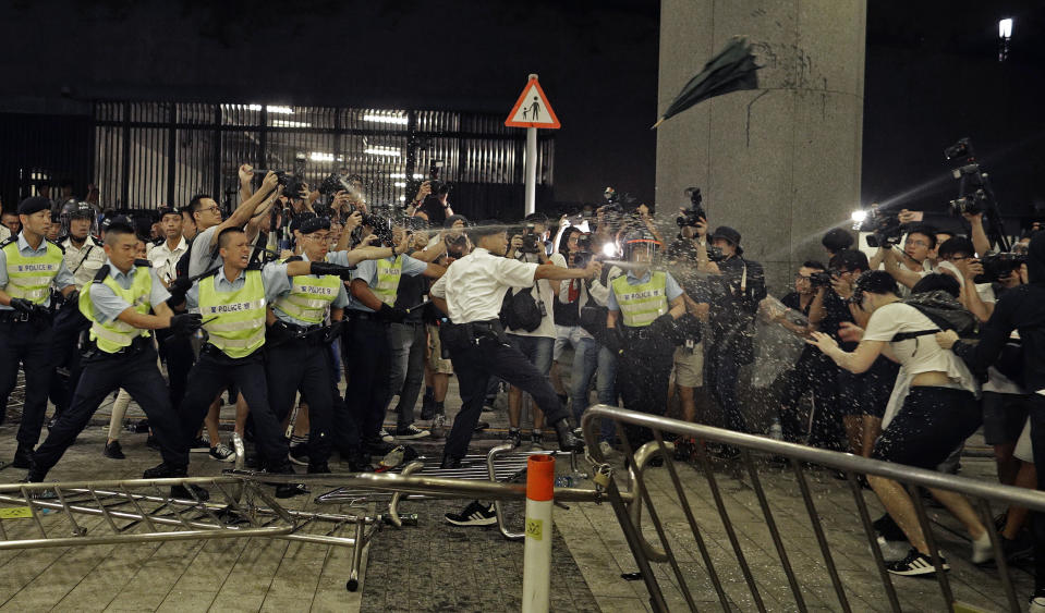 Police officers use pepper spray against protesters in the rally as chaos breaks out. Source: AP    