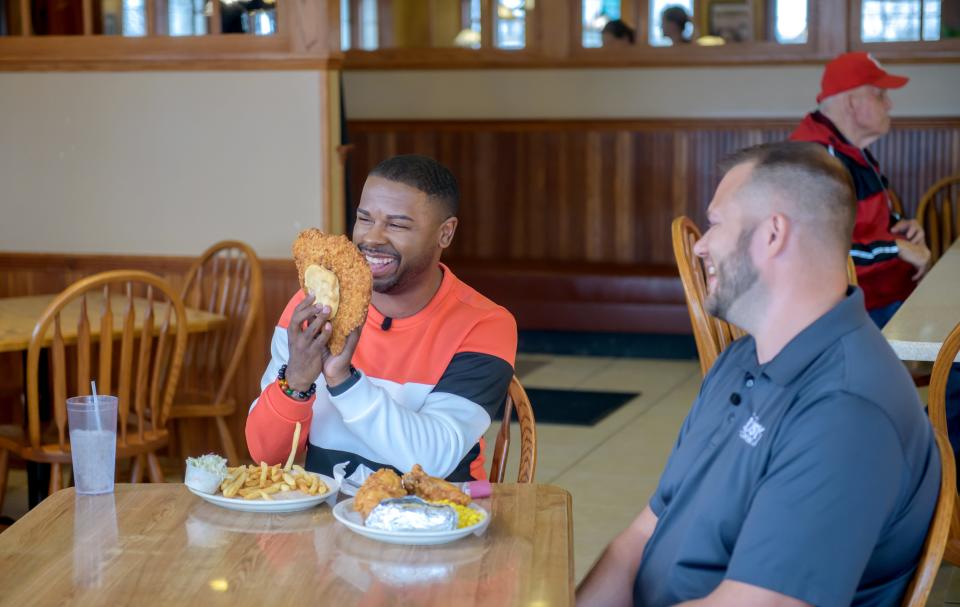 "America's Best Restaurants" host J Russell, left, gets a kick out of the size and heart shape of a tenderloin during filming of an episode of the online show at the Busy Corner restaurant Wednesday, March 13, 2024 in Goodfield.
(Credit: MATT DAYHOFF/JOURNAL STAR)