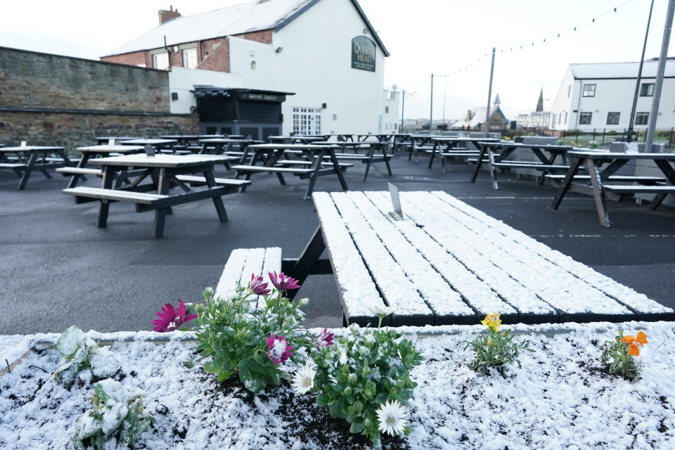 A light dusting of snow covers the outdoor seating area at the Queens Head in Cullercoats, on the North East coast, as the pub prepares to reopen its outdoor area from April 12, with customers welcome inside again from May 17. Picture date: Sunday April 11, 2021. (Photo by Owen Humphreys/PA Images via Getty Images)