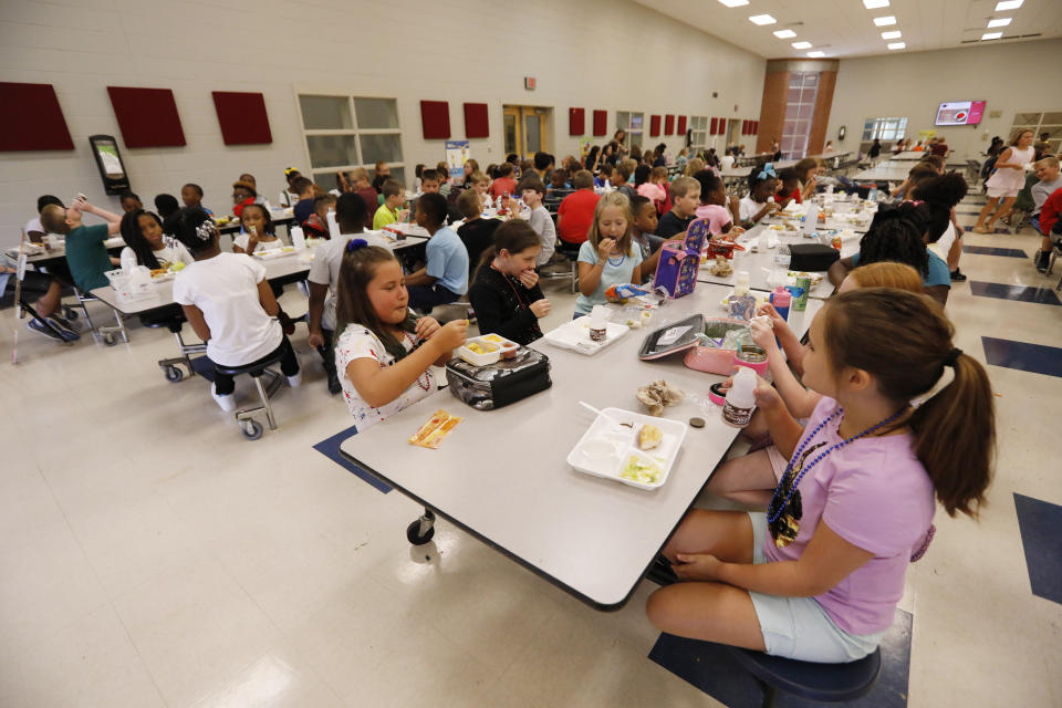 Students at Madison Crossing Elementary School in Canton, Miss., eat lunch in the school's cafeteria on Friday, Aug. 9, 2019. Scott Clements, director of child nutrition at the Mississippi education department, said they've ordered two truckloads of trade mitigation pulled pork and four loads of kidney beans for use in their school meal plans. The products are coming from the U.S. Department of Agriculture, which is giving away the foods it’s buying to help farmers hurt by trade negotiations. (AP Photo/Rogelio V. Solis)