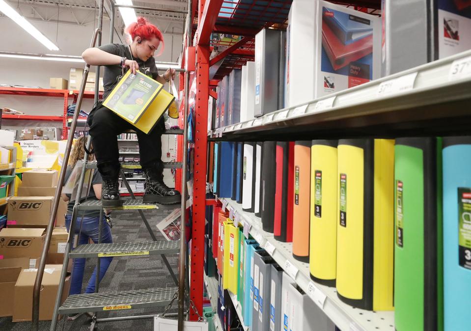 Riley Nash, an inventory specialist at Staples on Arlington Road, stocks binders on the shelf as the store prepares for back to school sales in Akron on Monday, July 18, 2022.