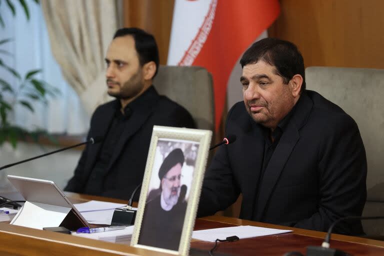 Una fotografía publicada por la presidencia iraní muestra al primer vicepresidente de Irán, Mohammad Mokhber (derecha), con el asiento vacío del difunto presidente Ebrahim Raisi (retrato) junto a él, dirigiéndose al gabinete del país en Teherán el 20 de mayo de 2024.