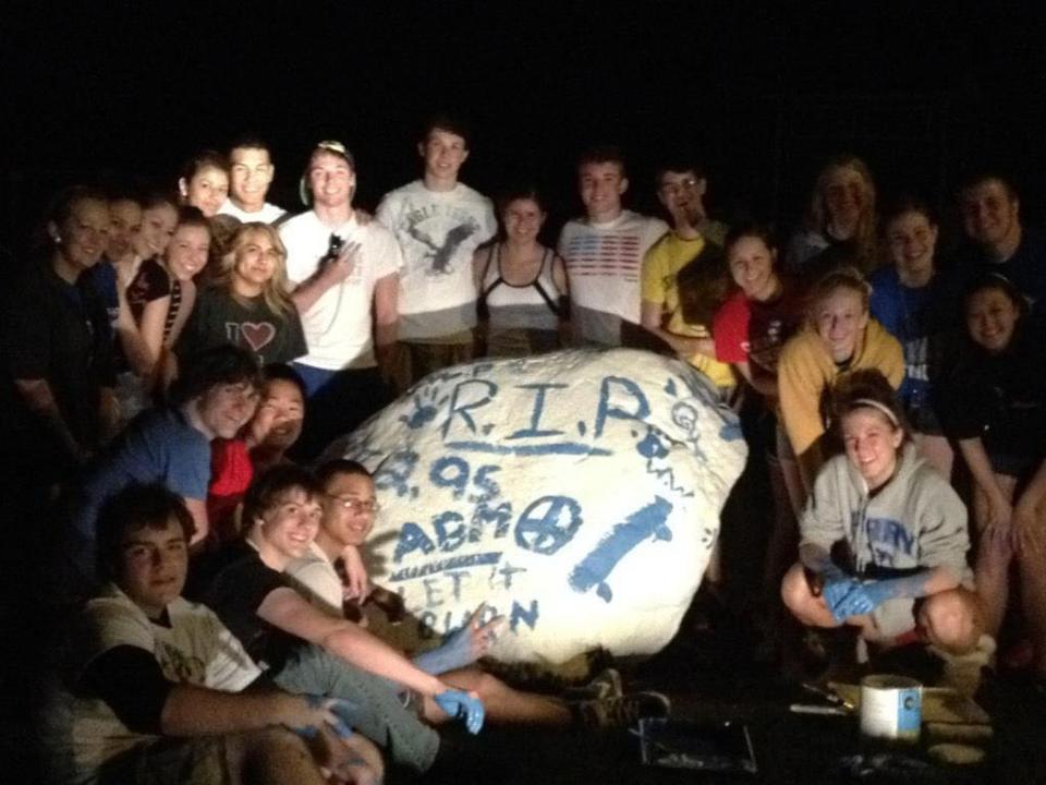 Members of the Perry High School Class of 2014 pose for a photo after painting a rock on campus in honor of their late classmate, Alex Macias, in April of 2012. With their help and that of the Class of 2024,t he rock has now been painted bright blue to recognize Ahmir Jolliff, who was killed in a Jan. 4 shooting at the school.