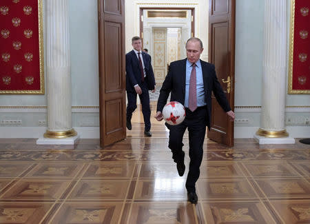 Russian President Vladimir Putin plays with a ball following a meeting with FIFA President Gianni Infantino at the Kremlin in Moscow, Russia November 25, 2016. Picture taken November 25, 2016. Sputnik/Alexei Druzhinin/Kremlin via REUTERS/Files