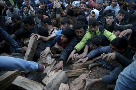 Migrants who are waiting to cross the Greek-Macedonian border, scuffle to get a shipment of firewood near the village of Idomeni, Greece March 6, 2016. REUTERS/Marko Djurica