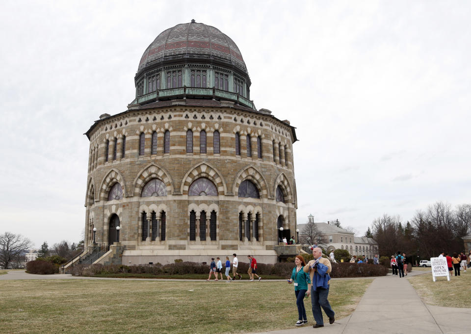 People walk by the Nott Memorial at Union College on Monday, April 14, 2014, in Schenectady, N.Y. Tiny Union, enrollment 2,200, defeated Minnesota, enrollment 48,000, Saturday for its first NCAA hockey title. (AP Photo/Mike Groll)