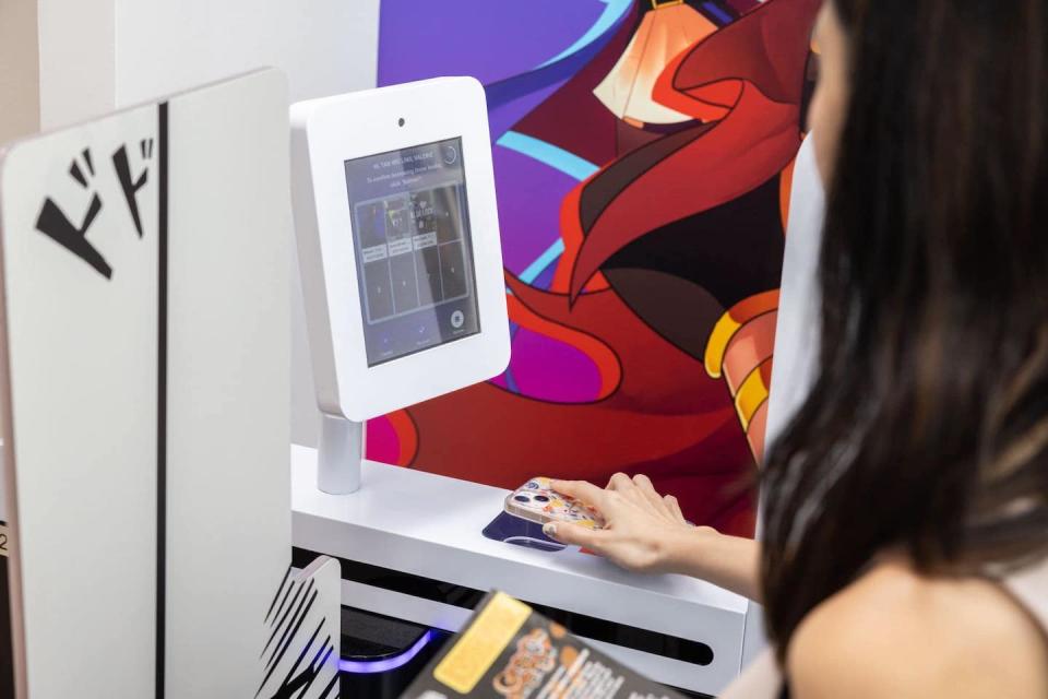 Woman using Grab-n-go NLB scanner (Photo: National Library Board/Facebook)