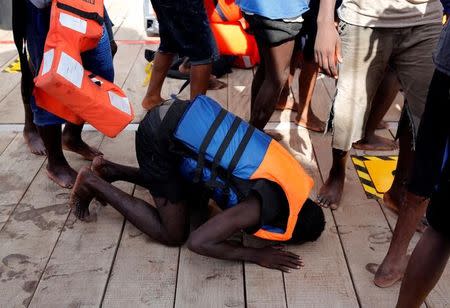 A migrant prays on his knees after boarding the Migrant Offshore Aid Station (MOAS) rescue ship Topaz Responder around 20 nautical miles off the coast of Libya, June 23, 2016. REUTERS/Darrin Zammit Lupi