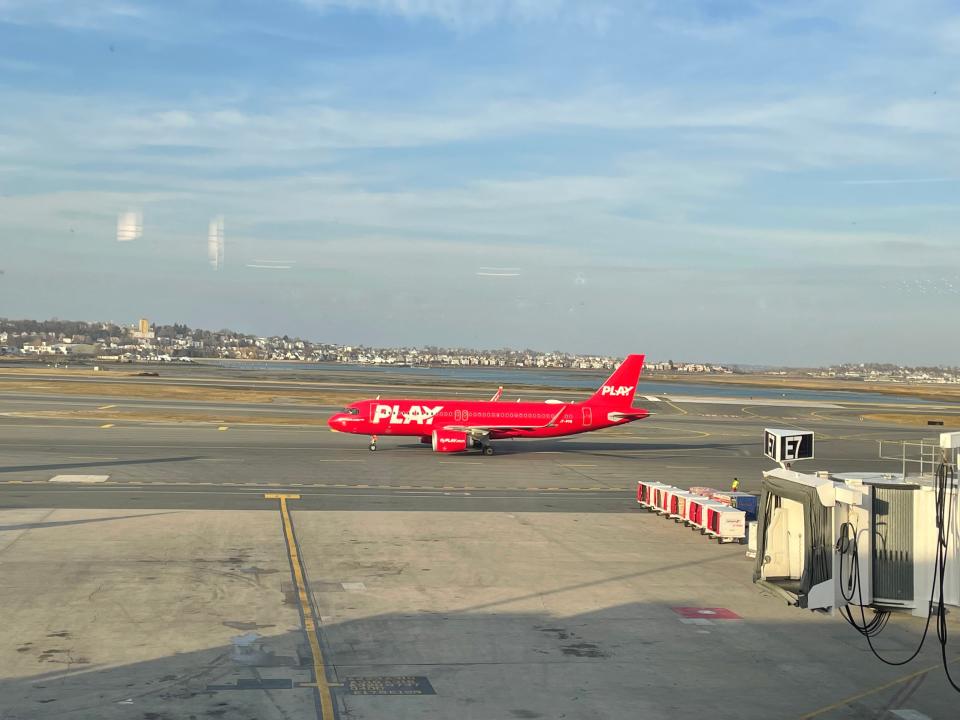 Red PLAY Airlines airplane on tarmac at Boston Logan Airport Asia London Palomba PLAY Airlines review