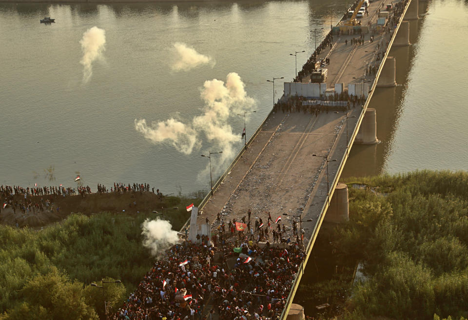 Security forces fire tear gas and close the bridge leading to the Green Zone during a demonstration in Baghdad, Iraq, Saturday, Oct. 26, 2019. (Photo: Hadi Mizban/AP)