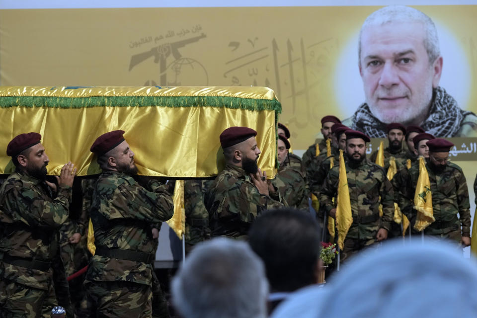 Hezbollah fighters carry the coffin of their comrade, senior commander Mohammad Naameh Nasser, who was killed by an Israeli airstrike that hit his car in the southern costal town of Tyre, during his funeral procession in the southern suburbs of Beirut, Lebanon, Thursday, July 4, 2024. (AP Photo/Bilal Hussein)