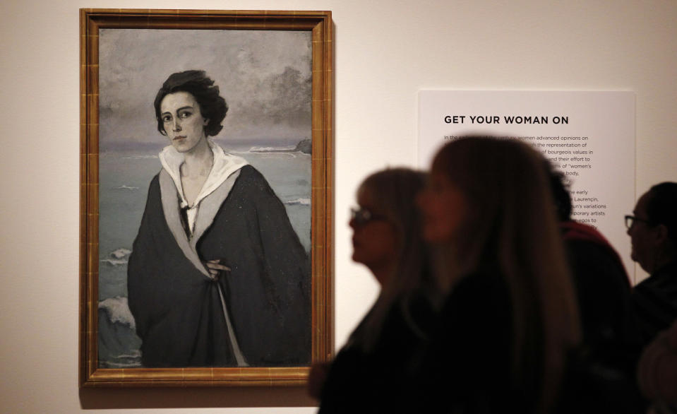 In this photo taken Tuesday, Oct. 9, 2012, visitors walk past an oil painting by Romaine Brooks (At the Edge of the Sea, 1914) as part of one of two new exhibits featuring art exclusively by women at the Seattle Art Museum, in Seattle. Included in the exhibition is the only U.S. stop for an exhibit from the Pompidou Center in Paris, home of the modern art museum there, of painting, sculpture, drawing, photography and video. The exhibit runs through Jan. 13, 2013. (AP Photo/Elaine Thompson)