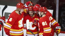 Calgary Flames' Johnny Gaudreau, center, celebrates his goal with teammates during second-period NHL hockey game action against the Vancouver Canucks in Calgary, Alberta, Monday, Jan. 18, 2021. (Jeff McIntosh/The Canadian Press via AP)