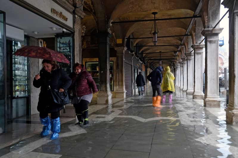 Tourists walk in St. Mark’s Square after days of severe flooding in Venice