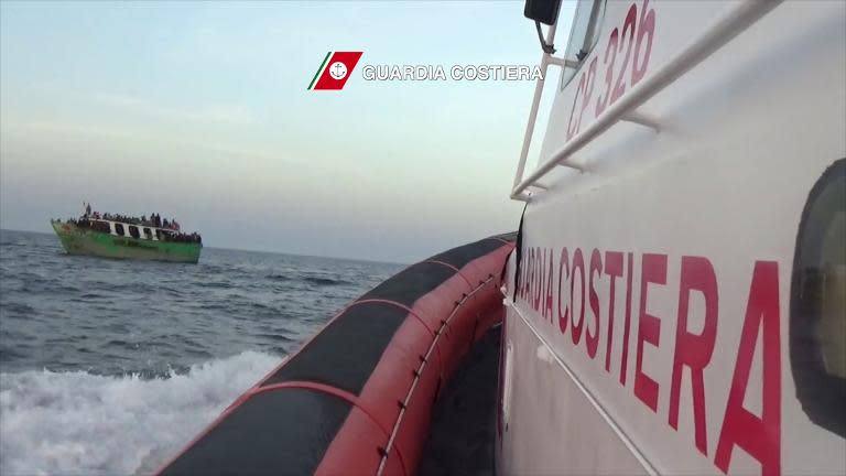 In this video grab released by the Italian Guardia Costiera on May 6, 2015 migrants gesture on a boat before a rescue operation