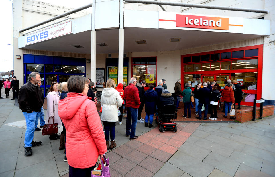 People are seen queueing up outside an Iceland at Melton Mowbray Market after NHS England announced that the coronavirus death toll had reached 104 in the UK.