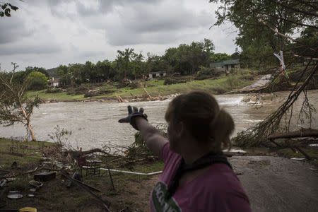 Amy Gilmour describes how the Blanco River crested at a record 43 feet during the Memorial Day weekend floods while helping pick up debris from the backyards of flood damaged homes in Wimberley, Texas May 26, 2015. REUTERS/Tamir Kalifa