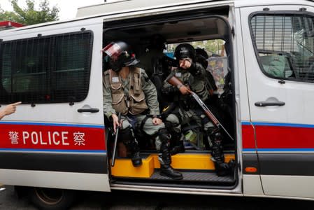 Riot police officers are pictured inside the police car in Tsuen Wan, near the site where police shot a protester with live ammunition on China's National Day in Hong Kong