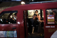 People wear masks as a precaution against coronavirus outbreak as they sit inside a public minivan locally known as 'angkot' in Jakarta, Indonesia, Thursday, Dec. 3, 2020. (AP Photo/Dita Alangkara)