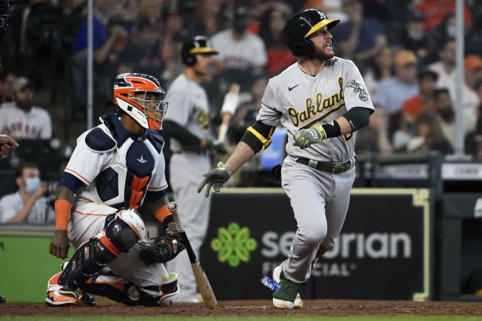 Oakland Athletics' Jed Lowrie, right, watches his two-run single during the seventh inning of a baseball game against the Houston Astros, Saturday, April 10, 2021, in Houston. (AP Photo/Eric Christian Smith)