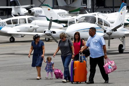 Passengers walk at the airstrip as they arrive at Charallave airport outside Caracas September 15, 2014. REUTERS/Carlos Garcia Rawlins